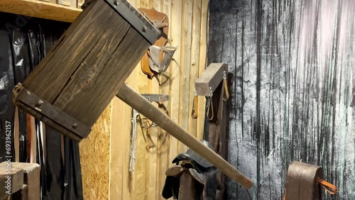 A large medieval wooden hammer hangs on a chain in a prisoner torture room. Thor's hammer photo