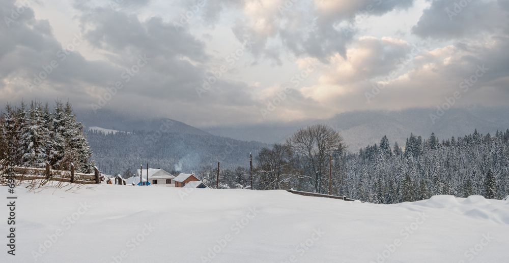 Snowfall over countryside hills, groves and farmlands in winter remote alpine mountain village