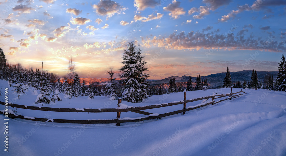 Winter snowy hills, tracks on rural dirt road and trees in last evening sunset sun light. Small and quiet alpine village outskirts. - obrazy, fototapety, plakaty 