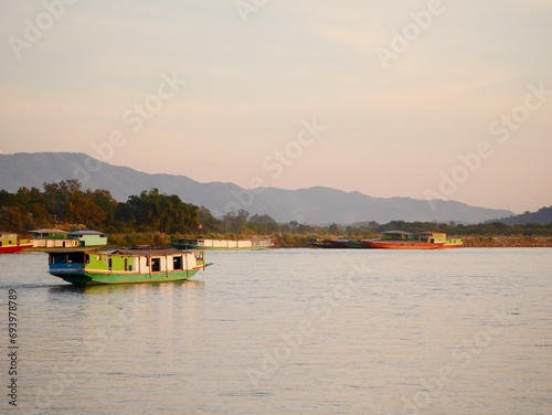 slow boat cruising along the Mekong River, Local boat moving on Mekong river between the border of Thailand and Laos, Boat transport on the river, transport ship