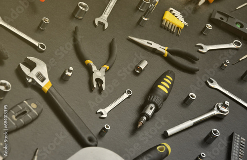 Handyman tool kit on black wooden table. Many wrenches and screwdrivers, pilers and other tools for any types of repair or construction works. Repairman tools set photo