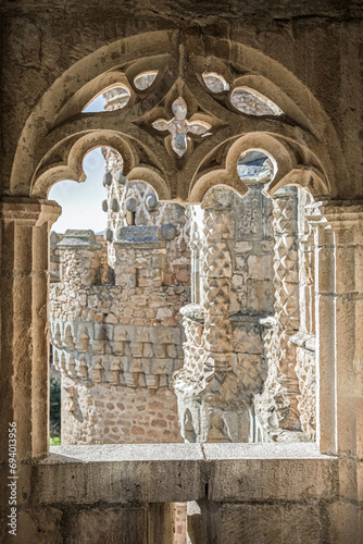 The window of the ancient medieval castle in the Gothic style overlooks the beautiful carved towers of the castle. El Castillo de Manzanares el Real, Madrid, Spain.