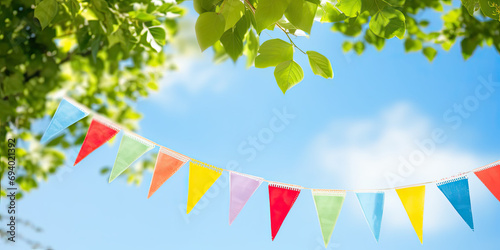 Colourful pennant string decoration in the forest with sky 