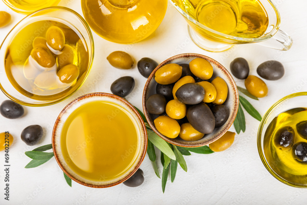 Olive oil in a bottle on a white texture background. Oil bottle with branches and fruits of olives. Place for text. copy space. cooking oil and salad dressing.