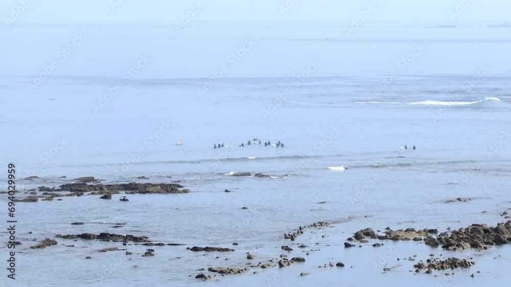 Surfers in the water of Erromardie beach seen from the Archilua cliff in Saint-Jean-de-Luz, France Surfers in the water of Erromardie beach seen from the Archilua cliff in Saint-Jean-de-Luz, France