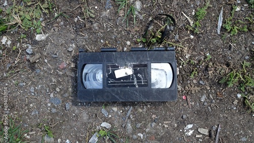 An old broken video cassette abandoned on the ground, testimony to a time gone by.
