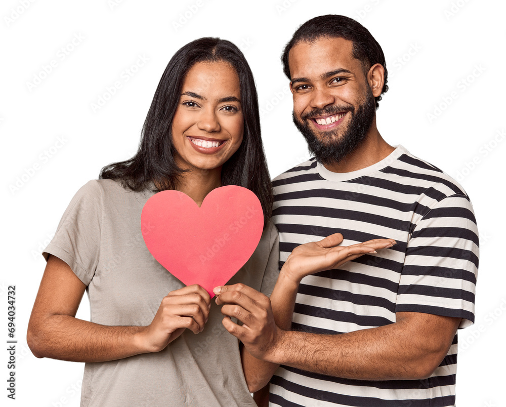 Latina couple with Valentine's sign showing a copy space on a palm and holding another hand on waist.