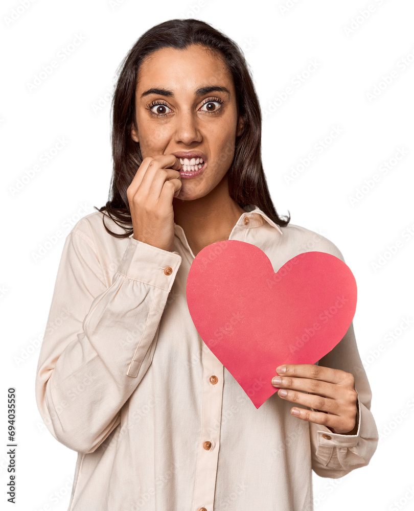 Caucasian young woman with paper heart for Valentine's biting fingernails, nervous and very anxious. Caucasian young woman with paper heart for Valentine's biting fingernails, nervous and very anxious.