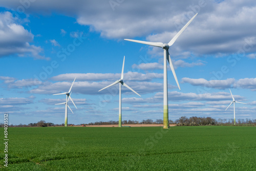Wind turbines in a field in a rural area  with blue sky and white clouds
