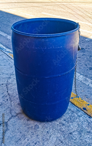 Blue trash garbage cans dirty street Playa del Carmen Mexico.
