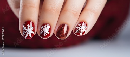 Snowy red nails design for women during Christmas at a nail salon.