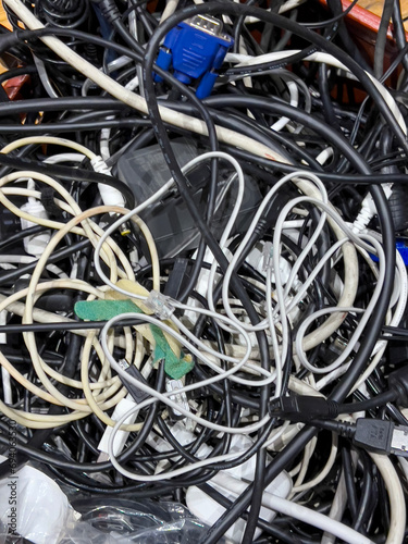 jumble of computer wires and cables on wooden floor