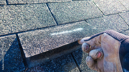 Residential roof inspection for an insurance claim due to storm damage. The asphalt shingles show signs of damage. 