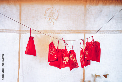 Photography Christmas calendar with red goodie bags hanging in the kitchen window