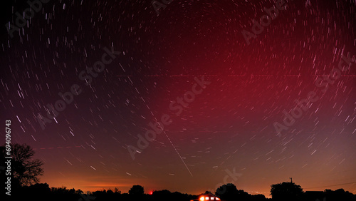 Long exposure of a Stable Auroral Red arc, or SAR arc, a rare space phenomenon over north east Oklahoma sky on November 5th, 2023; with star trails, airplane and satellite tracks crossing the sky photo