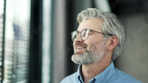 Close up of mature gray haired bearded businessman relaxing with closed eyes in business office. Portrait of calm happy senior male resting, breathing deeply. The smiling owner took a break from work photo