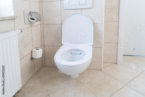 Modern white wc bowl in beige bathroom toilet close up