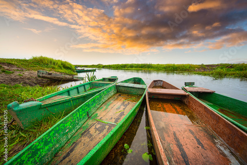 Fototapeta Naklejka Na Ścianę i Meble -  Zachód słońca na rzece z łodziami