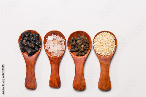 Many different spices in wooden spoons, background with different spices, spices on a white background