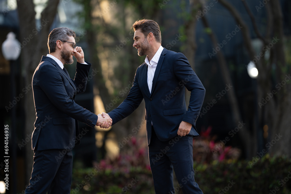 Two successful businessmen smiling at the camera. Handshake business people. two business man. Two business men discussed their strategy. Two successful businessmen smiling at the camera Two successful businessmen smiling at the camera. Handshake business people. two business man. Two business men discussed their strategy. Two successful businessmen smiling at the camera