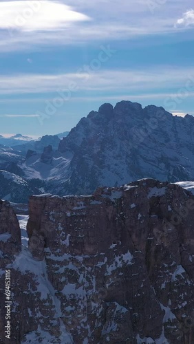 Tre Cime Di Lavaredo and Sextenstein. The Three Peaks on Sunny Day in Winter. Aerial View. Sexten Dolomites, South Tyrol, Alps. Italy. Orbiting. View from the North. Vertical Video photo