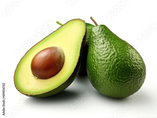 An avocado cut in half and a whole avocado.