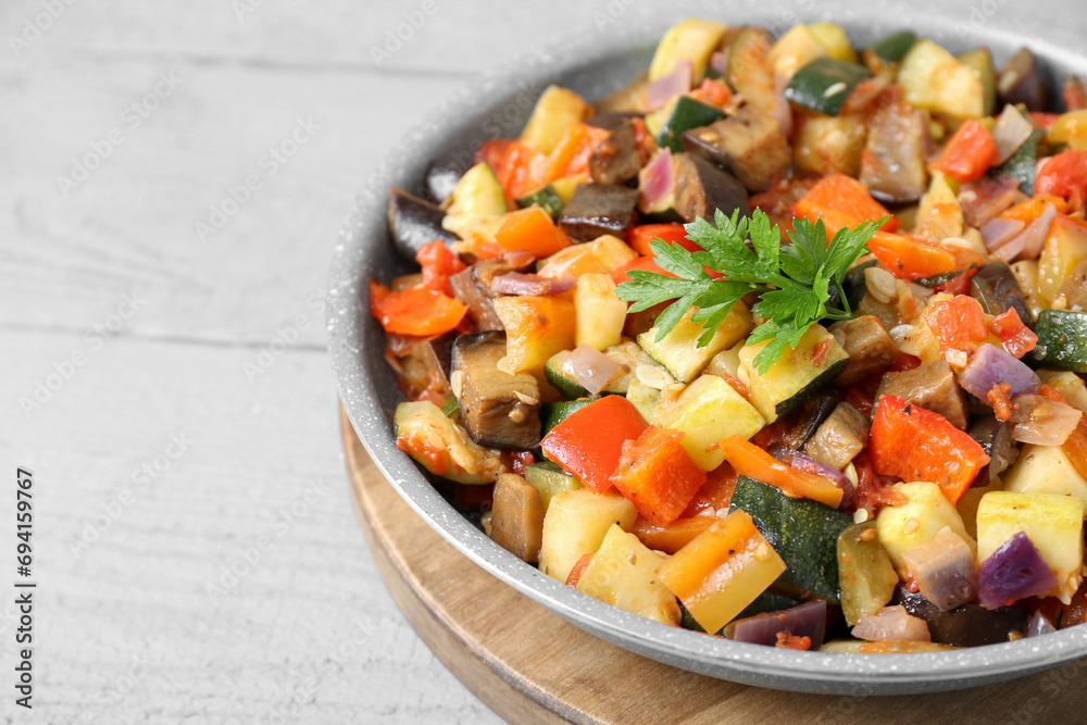 Delicious ratatouille in frying pan on grey wooden table, closeup Delicious ratatouille in frying pan on grey wooden table, closeup