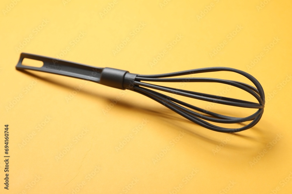 Plastic whisk on yellow background. Kitchen tool Plastic whisk on yellow background. Kitchen tool
