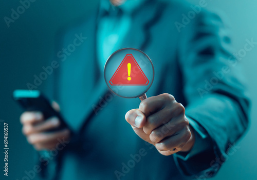 magnifying glass shows a warning sign of system failure. concept notification a spam, risk of website technology digital online. caution danger if is attacked cyber error symbol, leak software data photo