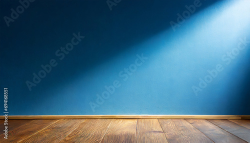 Empty room with blue wall and brown wooden floor.