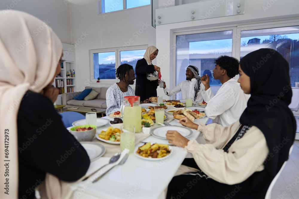 In the sacred month of Ramadan, a Muslim family joyously comes together around a table, eagerly awaiting the communal iftar, engaging in the preparation of a shared meal, and uniting in anticipation In the sacred month of Ramadan, a Muslim family joyously comes together around a table, eagerly awaiting the communal iftar, engaging in the preparation of a shared meal, and uniting in anticipation