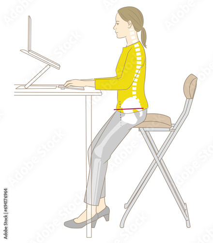 スタンディングデスクでパソコン作業をする女性