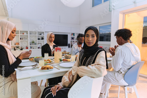 In the sacred month of Ramadan, a diverse Muslim family comes together in spiritual unity, fervently praying to God before breaking their fast, capturing a moment of collective devotion, cultural photo