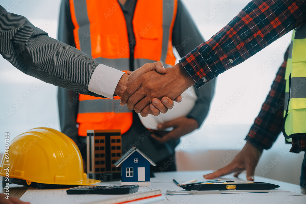 Construction and structure concept of Engineer or architect meeting for project working with partner and engineering tools on model building and blueprint in working site, contract for both companies. Construction and structure concept of Engineer or architect meeting for project working with partner and engineering tools on model building and blueprint in working site, contract for both companies.