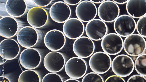 Galvanized steel pipe in stacks in a warehouse. Industrial building materials - aluminum alloy pipes  chrome-plated stainless steel.