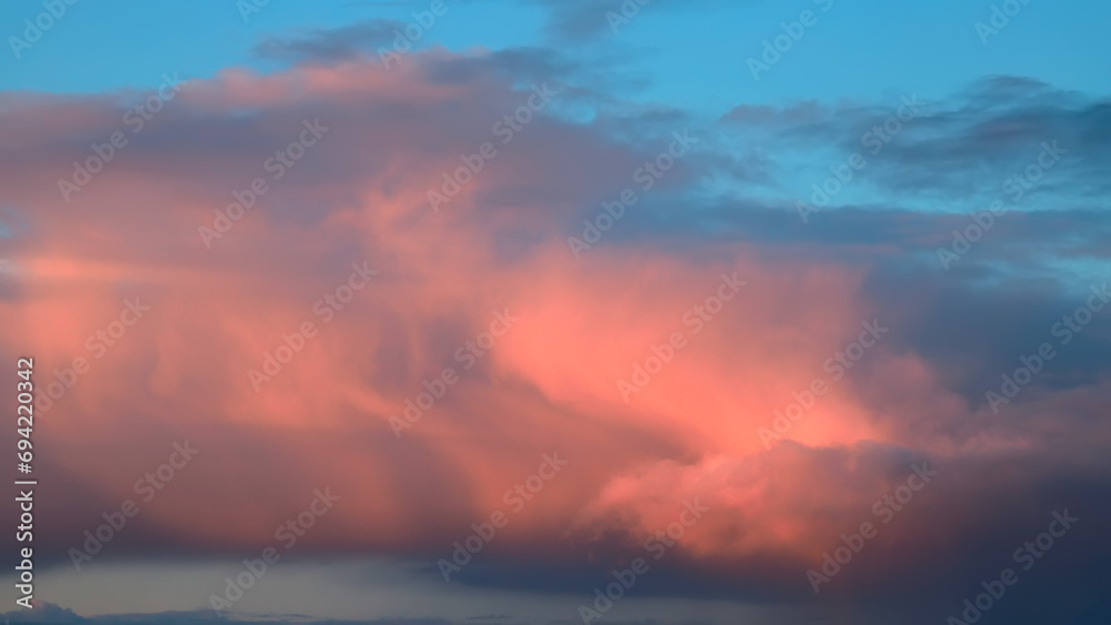 Cloud landscape in delicate pastel shades of pink and blue at sunset, romantic wallpaper, space for text, weather observation, nature after summer rain.