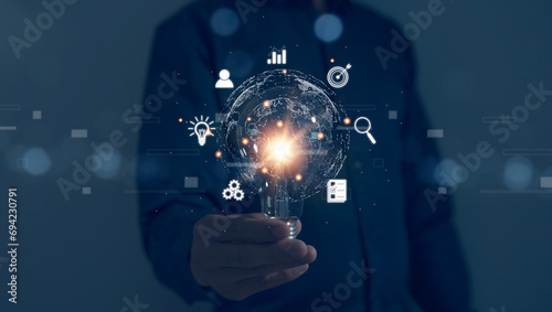 Businessman's hand holds a light bulb, global business internet connection application technology digital marketing Finance and digital link technology big data photo