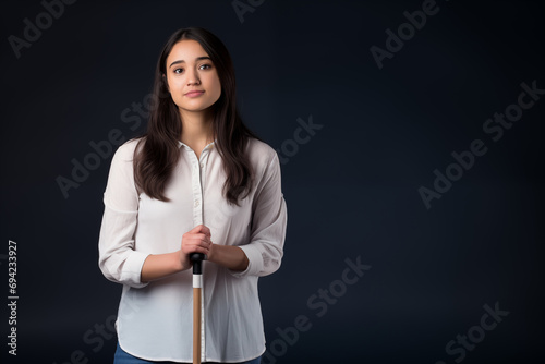 young woman holding walking stick, isolated on black studio background with copy space  photo