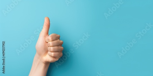 Thump up hand sign isolated on blue background. Business concept, banner photo