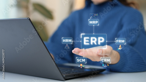 Enterprise Resource Planning (ERP). Woman uses computer work on program to help manage organization's system resources. photo