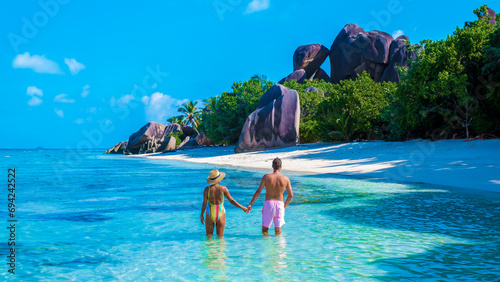 Anse Source d'Argent beach La Digue Island Seychelles, a couple of men and woman walking at the beach at a luxury vacation. a couple swimming in the turqouse colored ocean photo