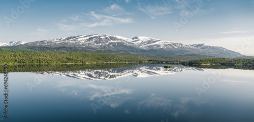 Peaceful mountain landscape with a serene lake reflection in Norway.