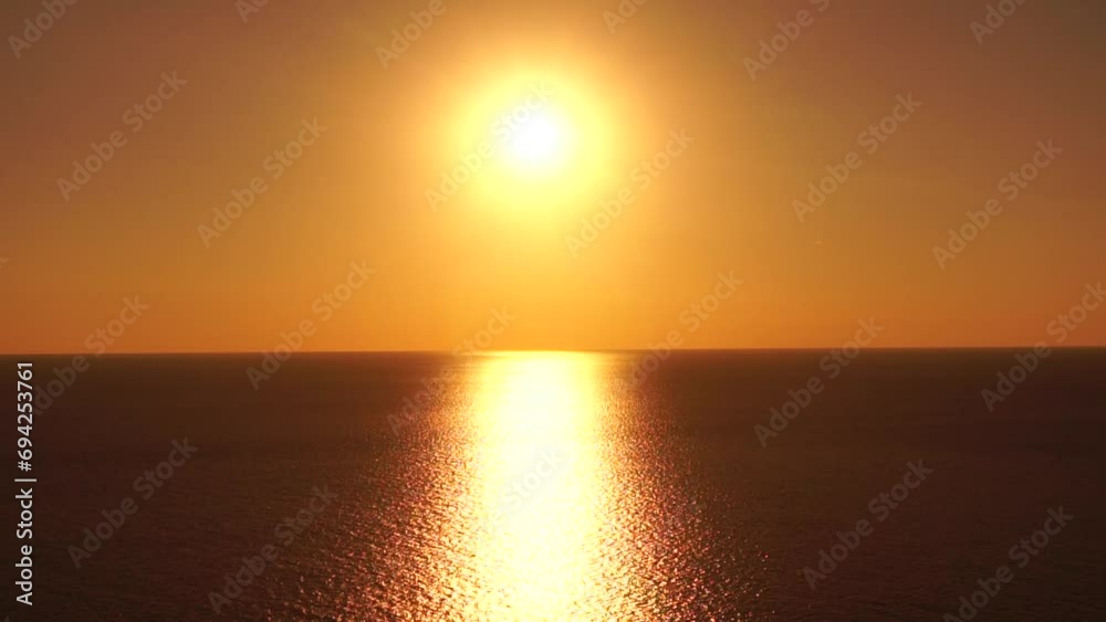 A red burning sunset over sea. Abstract nature summer ocean sea background. Small waves on golden warm water surface with bokeh lights from sun. Weather and climate change A red burning sunset over sea. Abstract nature summer ocean sea background. Small waves on golden warm water surface with bokeh lights from sun. Weather and climate change