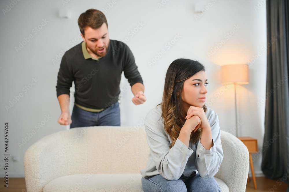Boyfriend and girlfriend are arguing at home. Angry man is yelling at his sad girlfriend Boyfriend and girlfriend are arguing at home. Angry man is yelling at his sad girlfriend
