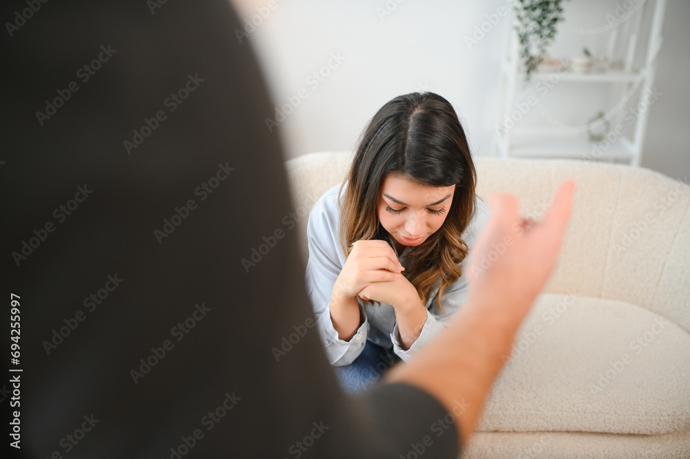 Irritated husband is shouting at his wife with violence. Woman is covering her face with fear Irritated husband is shouting at his wife with violence. Woman is covering her face with fear