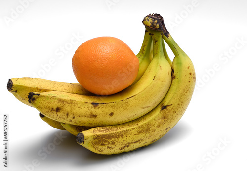 Kiść bananów z pomarańczą na białym tle 