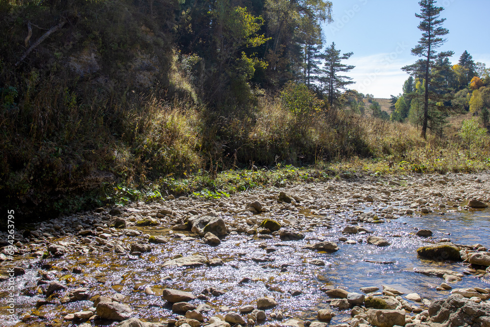 A shallow riverbed with a rocky bottom and shoals and fragments of stones A shallow riverbed with a rocky bottom and shoals and fragments of stones