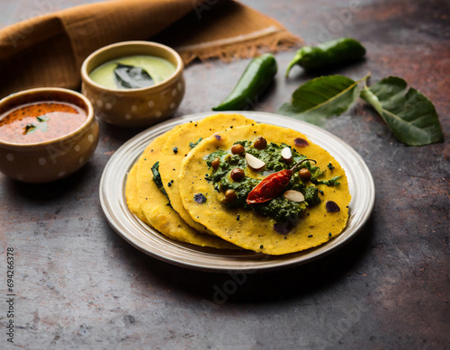 makki di roti with sarson ka saag, popular punjabi main course recipe in winters made using corn breads mustard leaves curry. served over moody background photo