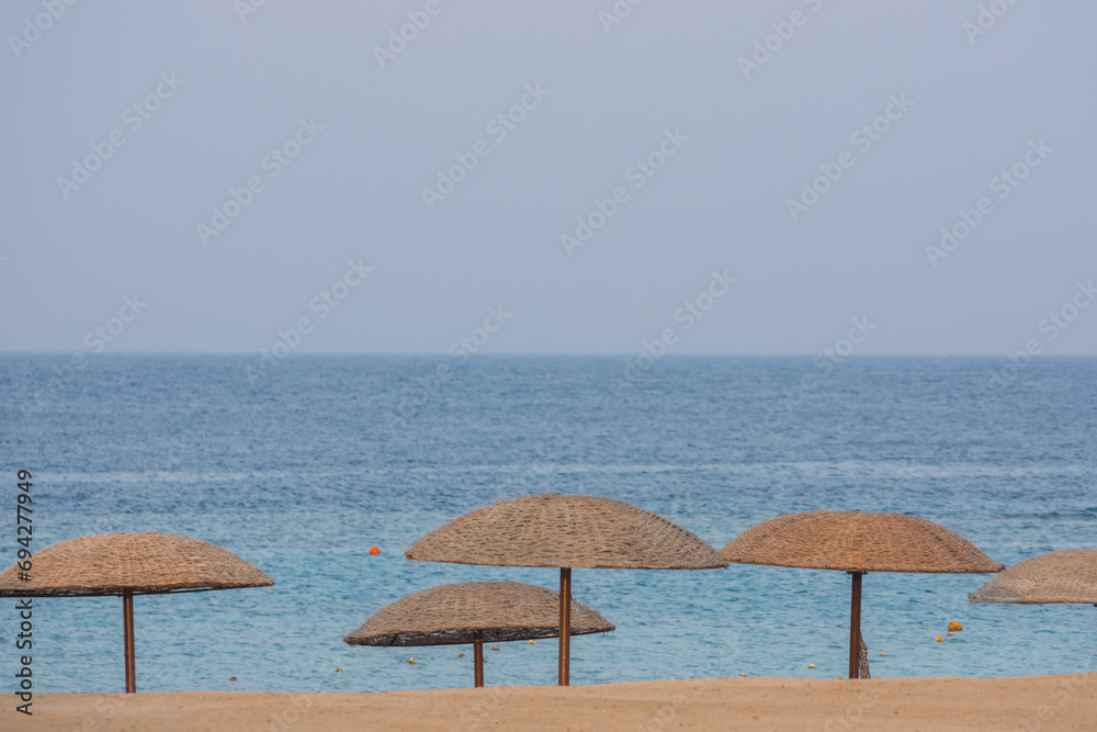 parasols in the sand from the beach with the horizon from the beach