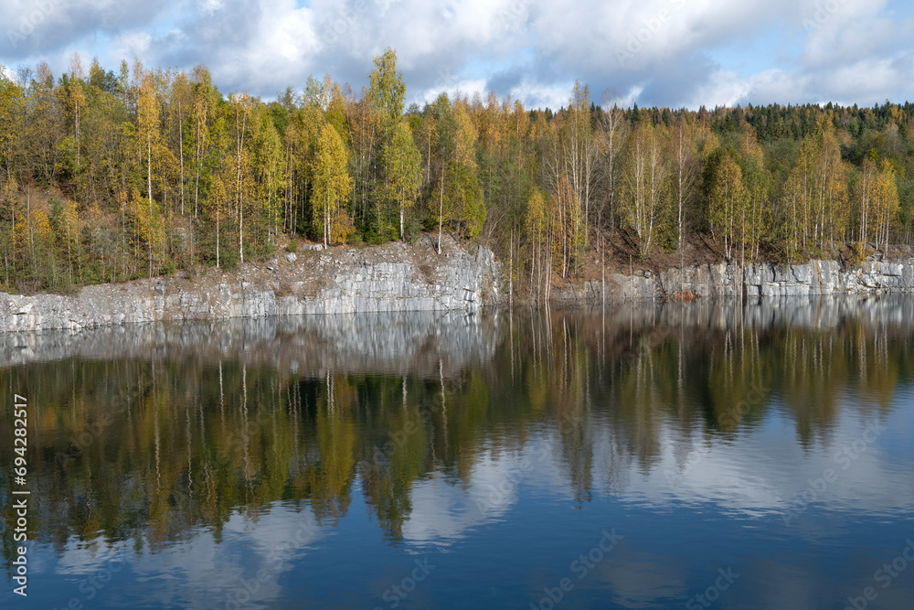 The shore of an old flooded marble quarry on a cloudy October day. The outskirts of the village of Ruskeala. Karelia, Russia